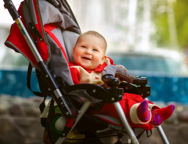 Smiling baby in sitting stroller on nature — Stock Photo, Image