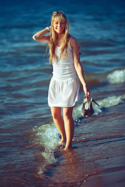 Okyanus kıyısındaki beyaz elbiseli güzel kadın — Stok fotoğraf