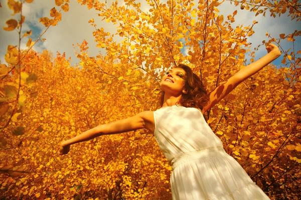 Brazos de mujer joven levantados disfrutando del aire fresco en el bosque de otoño — Foto de Stock