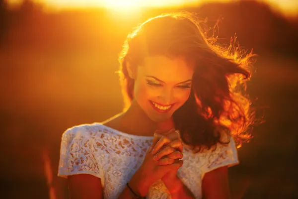 Una giovane ragazza prega ai raggi del tramonto — Foto Stock