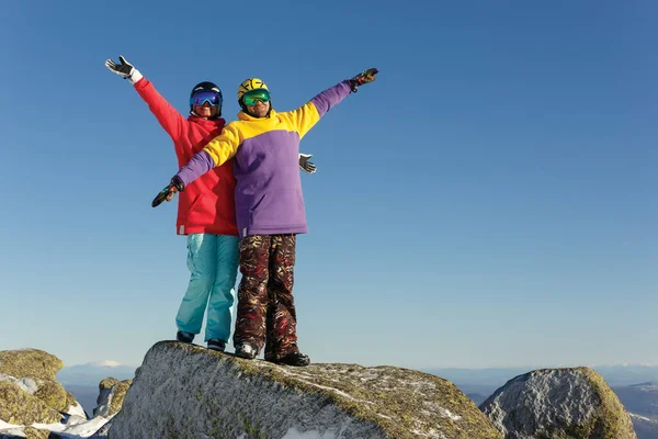 年轻的女孩和男子在滑雪胜地的山顶上玩得很开心 — 图库照片