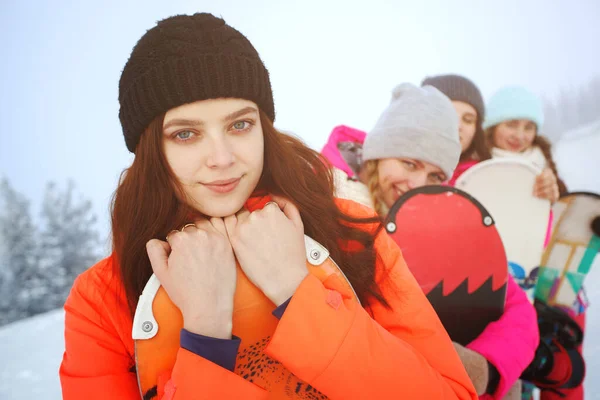 スキー場に立ってスノーボードを持つ幸せなスポーツ女性の写真 — ストック写真