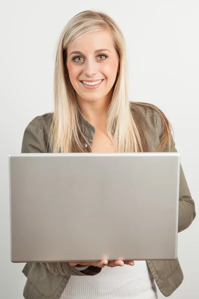 Porträtt av en ung blond kvinna leende med en bärbar dator — Stockfoto