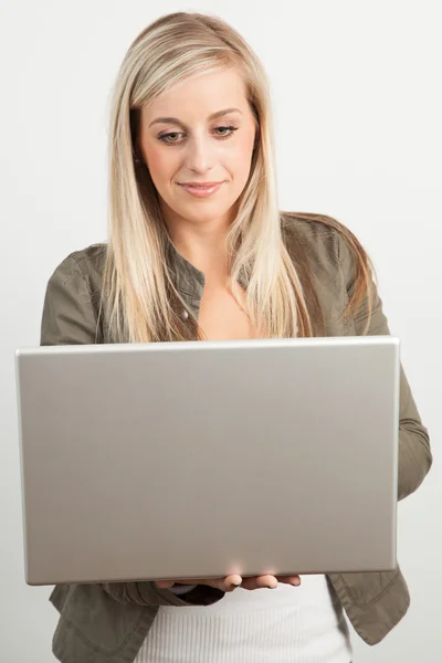一个年轻的金发女人微笑着用一台笔记本电脑的肖像 — 图库照片