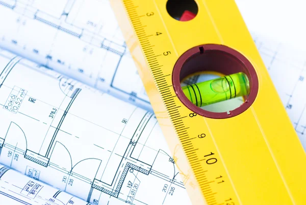 Spirit level and architectural drawings Royalty Free Stock Photos