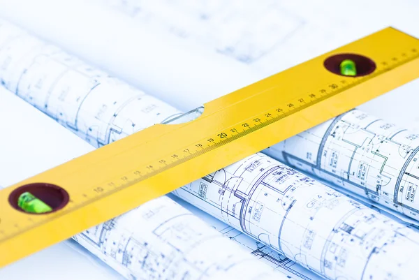 Spirit level and architectural drawings Royalty Free Stock Images