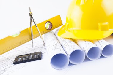 Sarı kask ve proje çizim ve inşaat araçları yığın