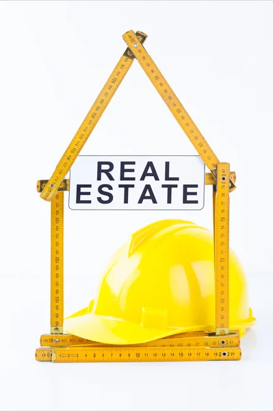 Yellow helmet with level and project drawings — Stock Photo, Image