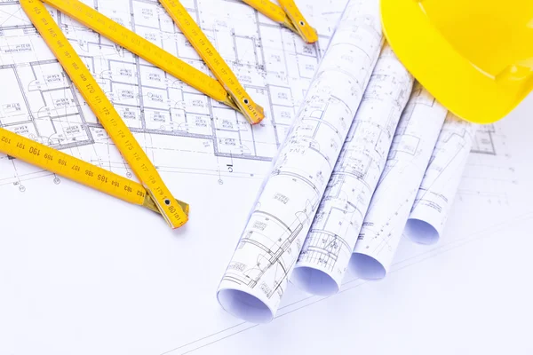 Rolos de planos arquitetônicos e ferramentas de construção — Fotografia de Stock