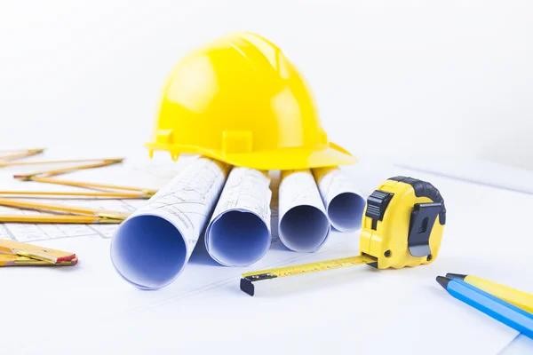 Gelber Helm und jede Menge Projektzeichnungen und Bauwerkzeuge — Stockfoto