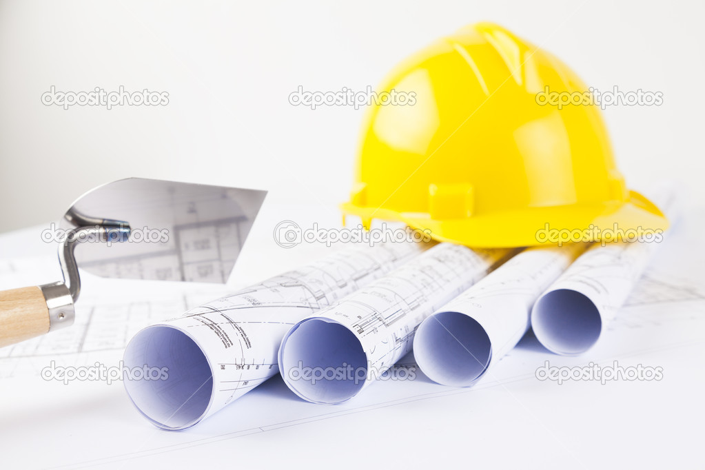 Yellow helmet with level and project drawings