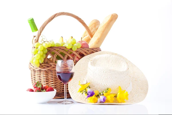 Cesta de picnic con botella de vino, frutas, pan y sombrero de verano aislado en blanco —  Fotos de Stock