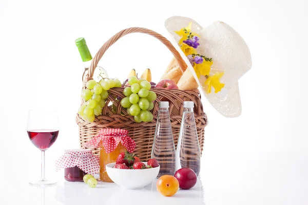 Picknickmand met fles wijn, fruit, brood en zomer hoed, geïsoleerd op wit — Stockfoto