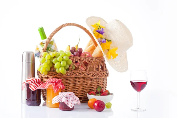 Cesta de picnic con botella de vino, frutas, pan y sombrero de verano aislado en blanco —  Fotos de Stock