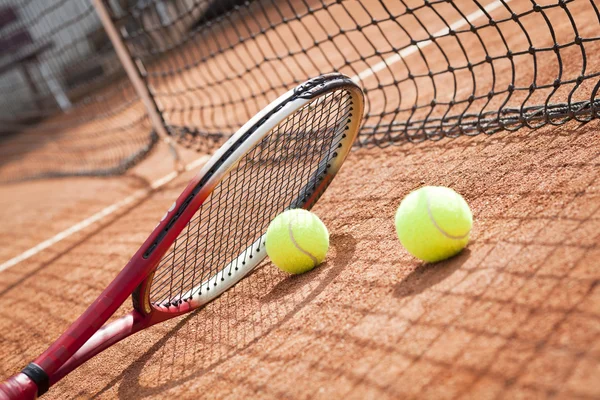 Close up of tennis racquet and balls on the clay tennis court — Stock Photo, Image