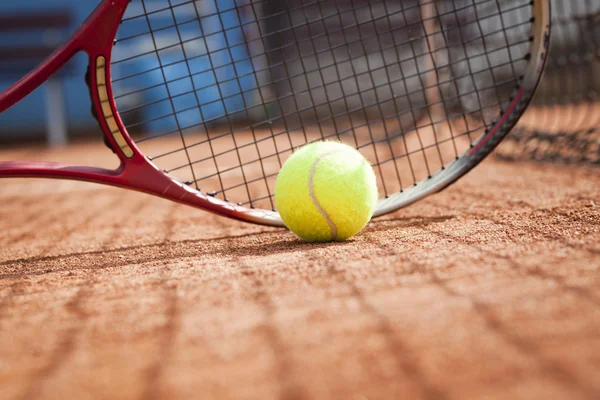 Primer plano de raqueta de tenis y pelotas en la cancha de tenis de arcilla — Foto de Stock