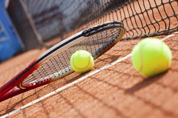 Primo piano racchetta da tennis e palline sul campo da tennis in terra battuta — Foto Stock