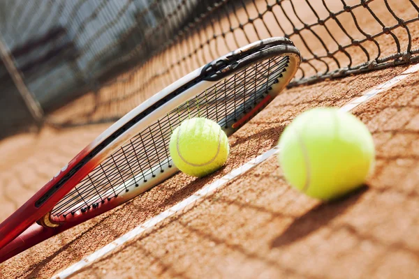 Close up of tennis racquet and balls on the clay tennis court — Stock Photo, Image