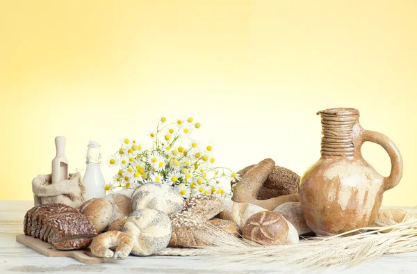 Freshly baked french bread with homespun fabric and wheat spikes on white background. — Stock Photo, Image