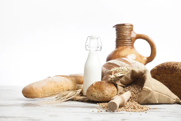 Freshly baked french bread with homespun fabric and wheat spikes on white background. — Stock Photo, Image