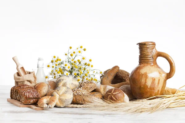Vers gebakken Frans brood met homespun weefsel en tarwe spikes op witte achtergrond. — Stockfoto