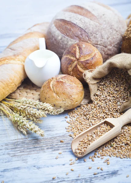 Rustic bread and wheat on an old vintage planked wood table. background with free text space — Stock Photo, Image