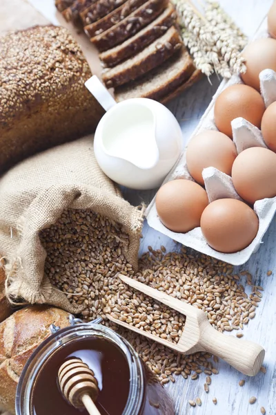 Rustika bröd och vete på en gammal vintage planked bord av trä. bakgrund med fritext utrymme — Stockfoto