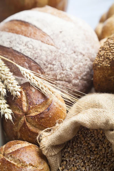 Freshly baked french bread with homespun fabric and wheat spikes on white background. — Stock Photo, Image