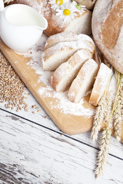 Rustic bread and wheat on an old vintage planked wood table. background with free text space — Stock Photo, Image