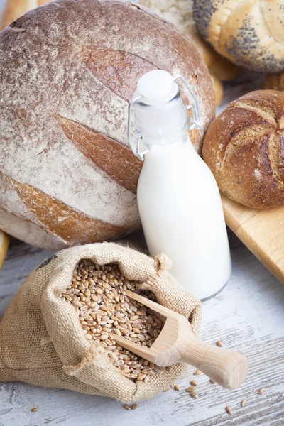 Rustic bread and wheat on an old vintage planked wood table. background with free text space — Stock Photo, Image