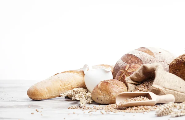 Freshly baked french bread with homespun fabric and wheat spikes on white background. — Stock Photo, Image