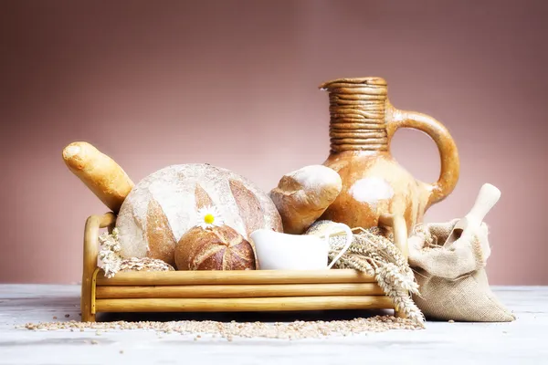 Freshly baked french bread with homespun fabric and wheat spikes on white background. — Stock Photo, Image