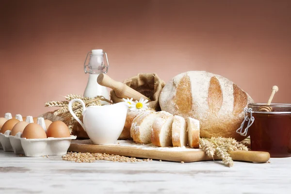 Freshly baked french bread with homespun fabric and wheat spikes on white background. — Stock Photo, Image