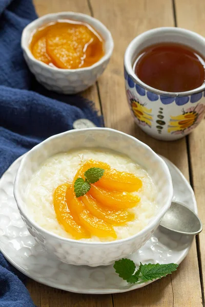 Frühstück aus Reisbrei mit Pfirsichmarmelade und Tee. Rustikaler Stil. — Stockfoto