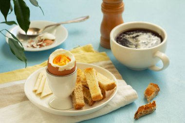 Haşlanmış yumurta, peynir, ekmek ve kahveyle kahvaltı. Kırsal biçim, seçici odak.
