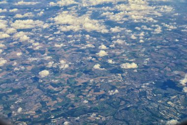 İngiltere kırsal alanı, tarlalar, çayırlar ve bulutlar. Sonsuz yemyeşil otlaklar ve tarlalardan oluşan uçaktan hava manzarası. Zümrüt yeşili tarlaları ve çayırları olan güzel bir İngiliz kırsalı. İngiltere.