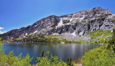 Silver Lake Flat Reservoir 'ın tatlı su gölü manzarası ve Tibble Fork' un yukarısındaki Tibble Fork Dağları American Fork Kanyonu. Wasatch Dağları, Utah. ABD.