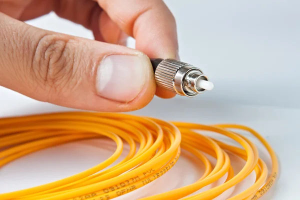 Man houdt een optische patchcord — Stockfoto