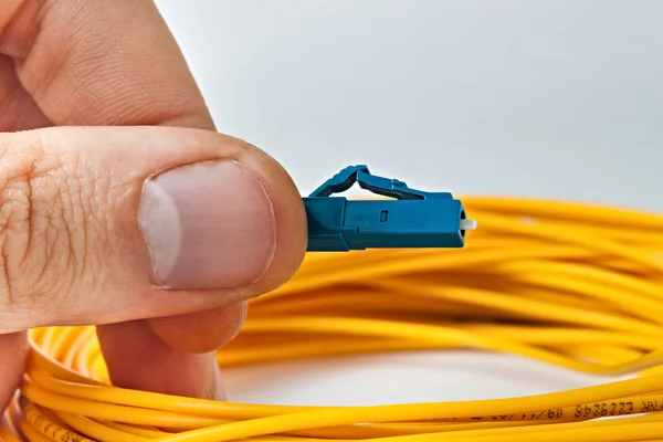 adam bir optik patchcord tutuyor