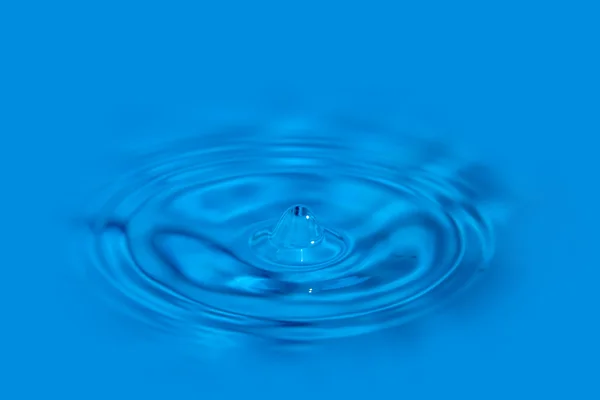 Macro water droplet with circles on a flat surface — Stock Photo, Image