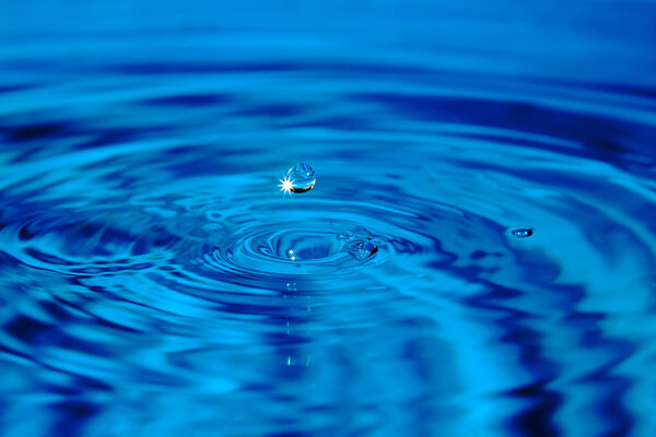 Glare falling droplets with circles on water