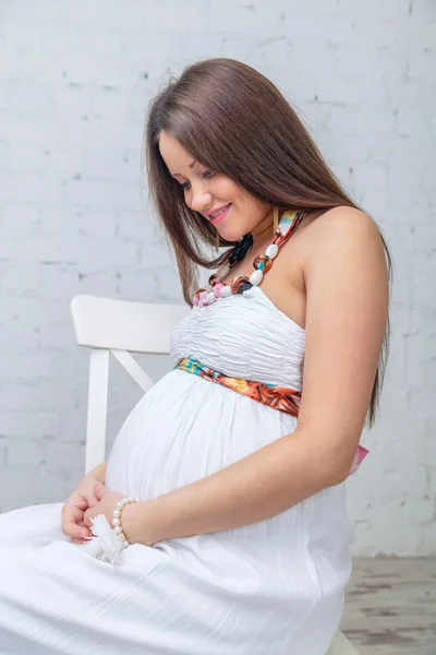 Vrouw zitten op de stoel kijken naar buik — Stockfoto