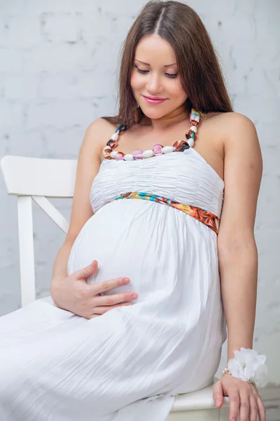 Vrouw zitten op de stoel houden zijn buik — Stockfoto