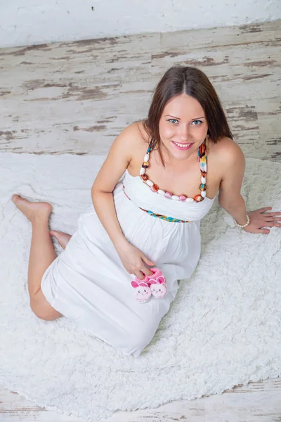 Wanita hamil memegang pandangan atas booties bayi — Stok Foto