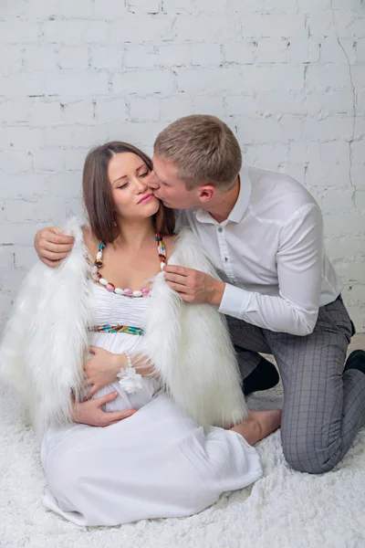 Мужчина целует свою беременную жену — стоковое фото