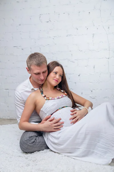 Мужчина обнимает свою беременную жену — стоковое фото