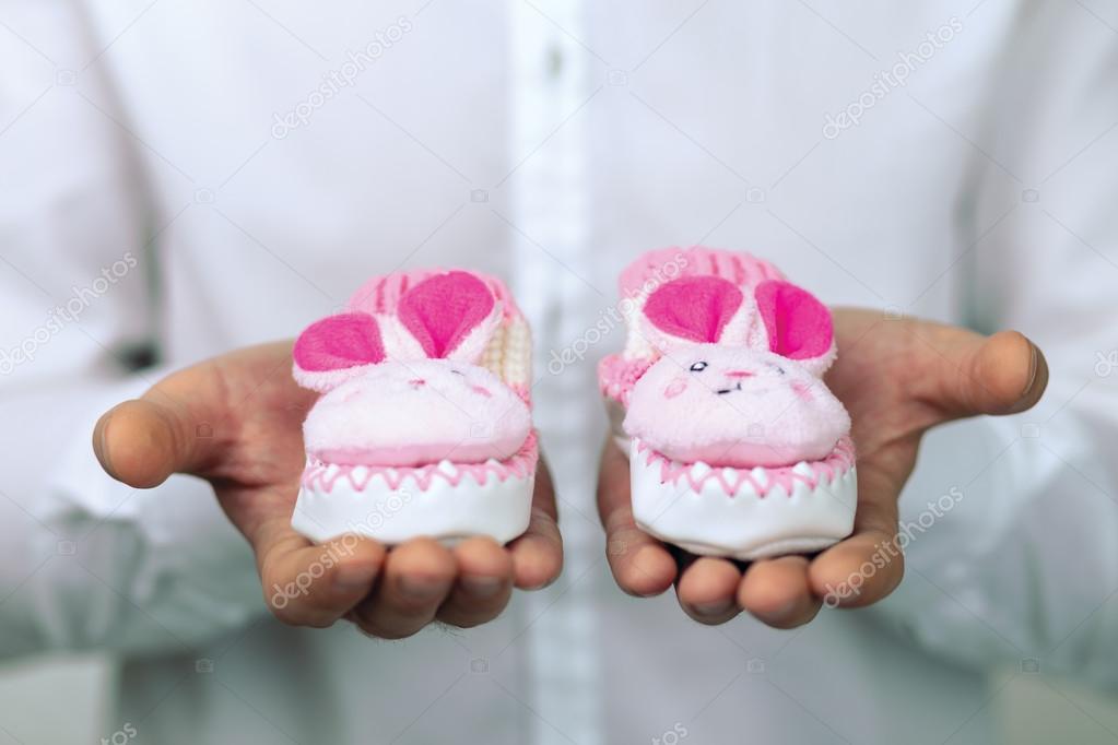 Young man holding baby booties