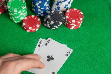 İki as ve yeşil masada poker fişleri yığını