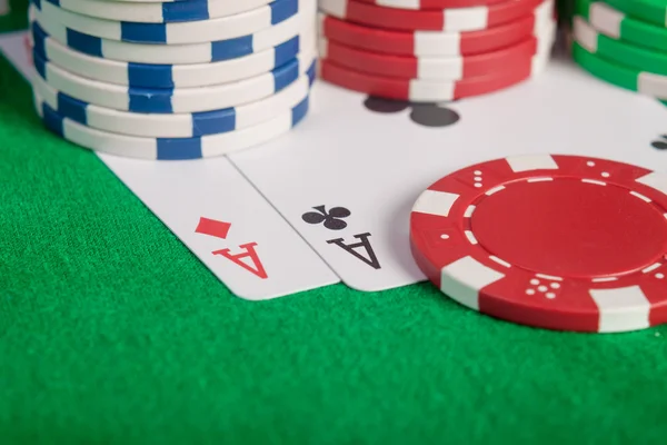 Macro par de ases e fichas de poker empilhar na mesa — Fotografia de Stock