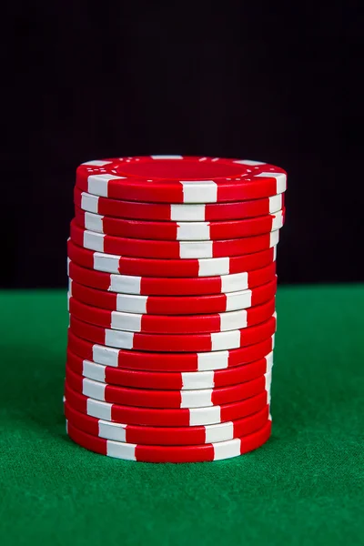 Stack of red chips on a green playing table — Stock Photo, Image